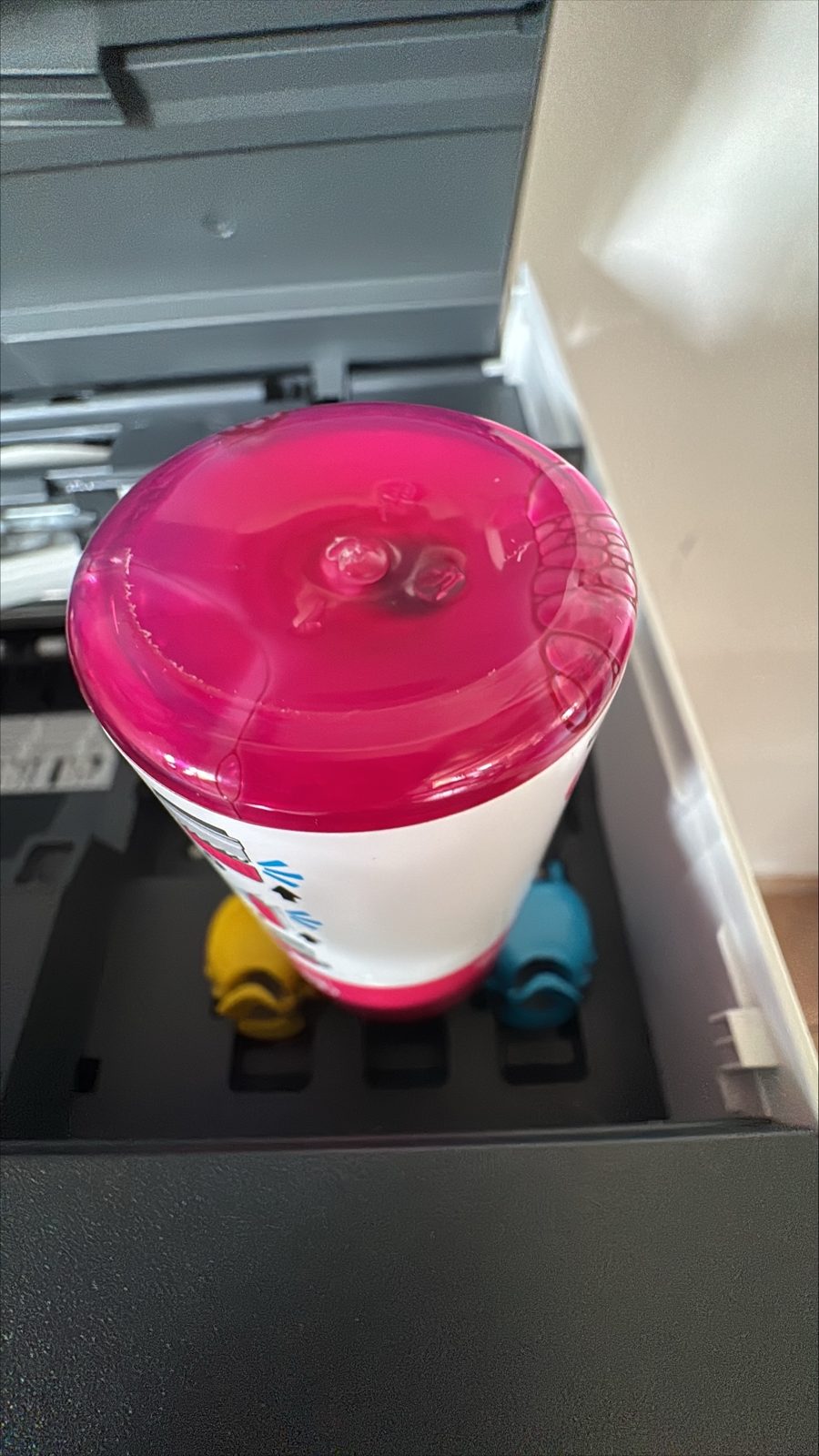 Magenta Tintenflasche von oben beim tropffreien Nachfüllen